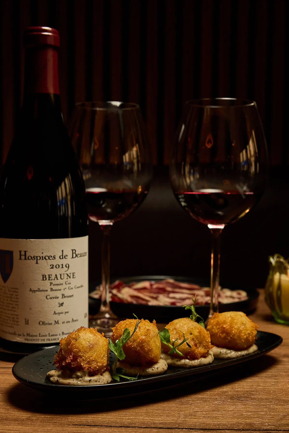 Entrées avec arancini et pata negra accompagnées de vin rouge dans un restaurant à Paris 9 – La Belle Quille