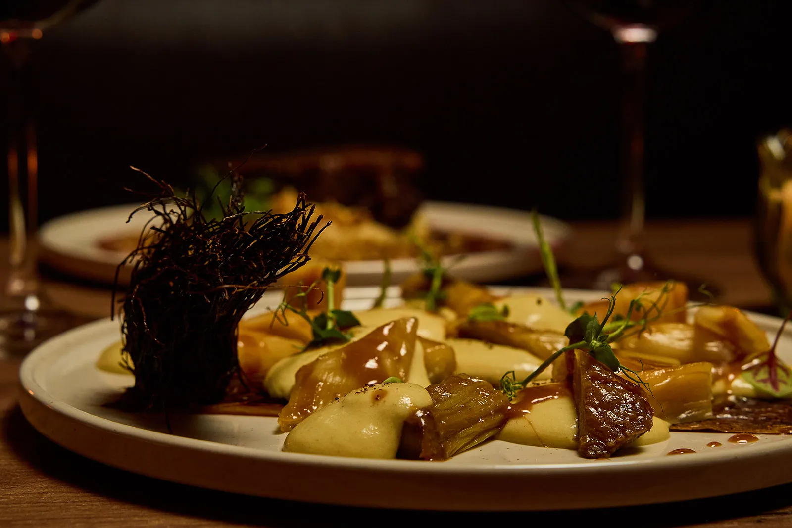 Plat de poireaux laqués au miso rouge avec espuma de pommes de terre dans un restaurant à Paris 9 – La Belle Quille